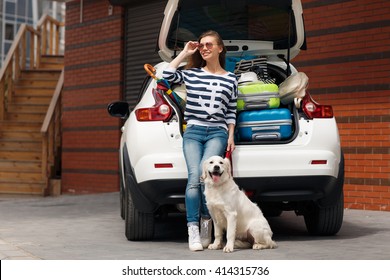 Woman With Dog By Car Full Of Suitcases. Car Trip. Woman And Dog In Car On Summer Travel. Getting Ready For Road Trip. 