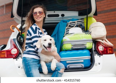 Woman With Dog By Car Full Of Suitcases. Car Trip. Woman And Dog In Car On Summer Travel. Getting Ready For Road Trip. 