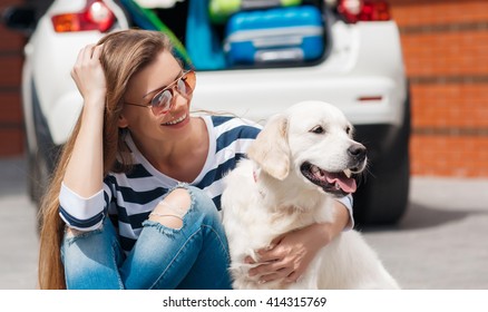 Woman With Dog By Car Full Of Suitcases. Car Trip. Woman And Dog In Car On Summer Travel. Getting Ready For Road Trip. 