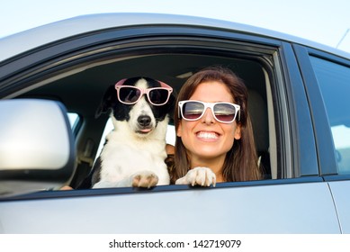 Woman and dog in car on summer travel. Funny dog with sunglasses traveling. Vacation with pet concept.