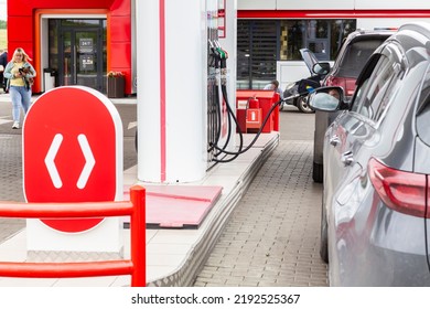 Woman With Dog At Gas Station Bought Gasoline Goes To Car, Black Cars Waiting For Fuel Tank Refueling. Man Services His Car At Lukoil Store Kemerovo, Russia August 20, 2022.