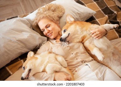 Woman And Dogs Lie On Bed, Family, Smiling. Relax, Spend Time Together, Enjoy And Have Fun. Lifestyle, Everyday Life. Beautiful