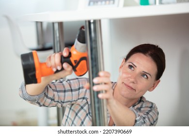 woman doig diy at home using a cordless drill - Powered by Shutterstock