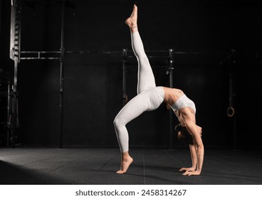 Woman doing acroyoga alone, solo. Flexibile woman focusing on yoga and acrobatics, preparing for partner exercises. - Powered by Shutterstock