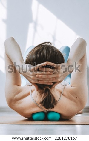 Woman doing back muscles myofascial release with two therapy massage balls