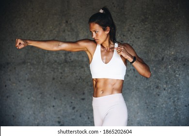 Woman Doing Boxing Workout Agasint A Wall. Female Doing Shadow Boxing Exercise.