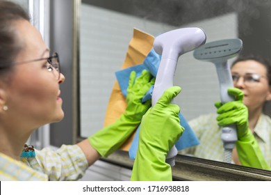 Woman Doing Cleaning In Bathroom Using Vacuum Cleaner, Without Use Of Household Chemicals. Close-up Of Gloved Hands With Steam In The Mirror, Eco-friendly Cleaning