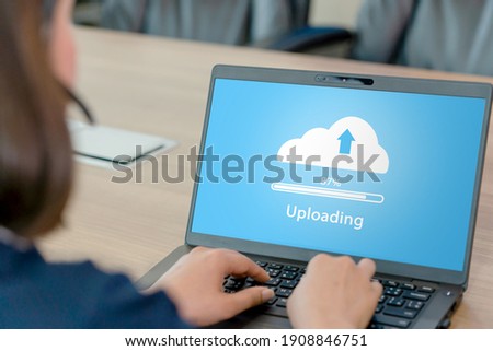 Woman doing cloud uploading on laptop in office. Data infomation