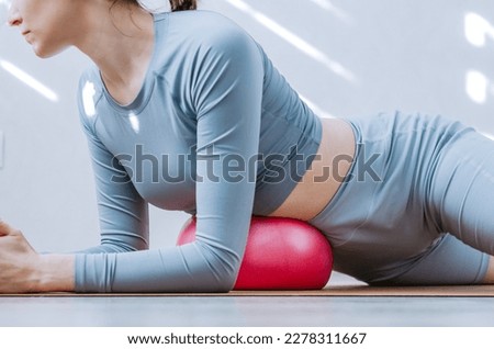 Woman doing diaphragm breathing exercises with soft pilates ball