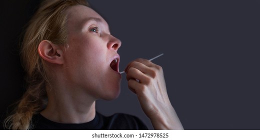 Woman Doing DNA Test With Cotton Swab At Home. Test For Home Use. Background With Copyspace