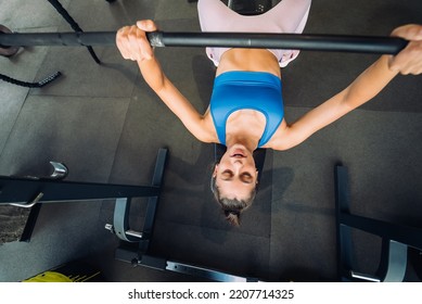 Woman Doing Exercises With Barbell On A Bench Press Training