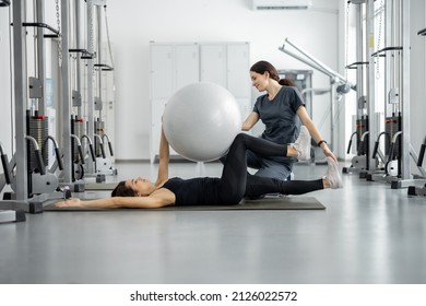 Woman doing exercises with fitness ball with rehabilitation specialist at the gym. Concept of physical therapy for health and recovery. Idea of recovery after pregnancy - Powered by Shutterstock