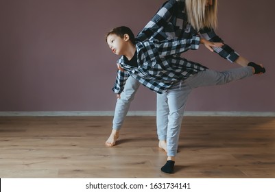 Woman doing exercises with a little son at gym. Concept of sports family and health. Closeup.