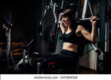 Woman Doing Fitness Exercises On Home Gym Lat Pulldown Machine.Making An Effort And Training Hard For Fit Body.Excess Body Weight.Toned Body.Home Weight Workout.Effort,dedication And Motivation