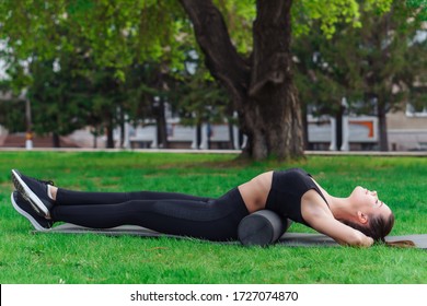 Woman Doing Foam Roller Exercise In Park