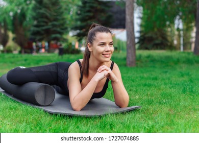 Woman Doing Foam Roller Exercise In Park