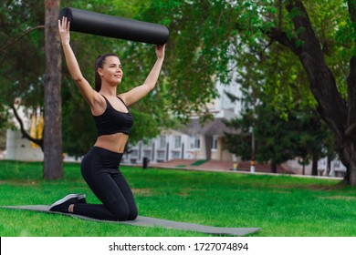 Woman Doing Foam Roller Exercise In Park