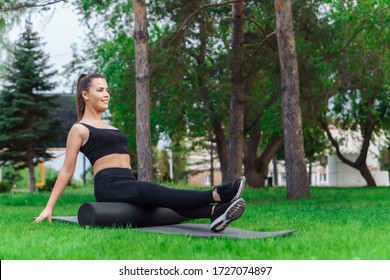 Woman Doing Foam Roller Exercise In Park