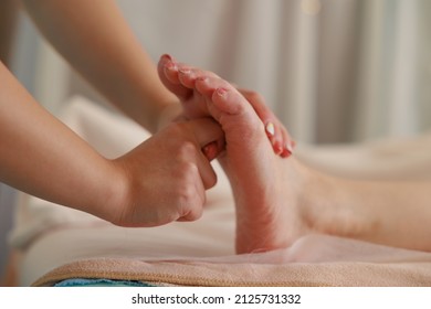 A woman doing a foot massage at an esthetic salon - Shutterstock ID 2125731332