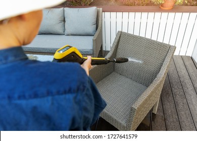 Woman Doing Garden Terrace Furniture Cleaning With High Pressure Washer