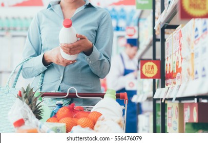 Woman doing grocery shopping at the supermarket and reading food labels, nutrition and quality concept - Shutterstock ID 556476079