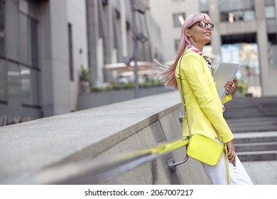 Woman Doing A Hair Flip While Holding Laptop On Stairs