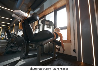 Woman Doing Hamstring Exercise In Fitness Club