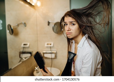 Woman Doing Her Hair Styling With A Brush At Home.Bad Hair Day.Daily Hairstyle Preparation Routine.Heat Damage,split Ends,dry Hair Loss.Getting Ready For Work.Blow Drying DIY Haircut.Home Hair Care