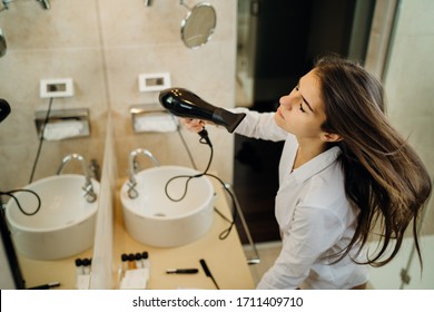 Woman Doing Her Hair Styling With A Brush At Home.Bad Hair Day.Daily Hairstyle Preparation Routine.Heat Damage,split Ends,dry Hair Loss.Getting Ready For Work.Blow Drying DIY Haircut.Home Hair Care