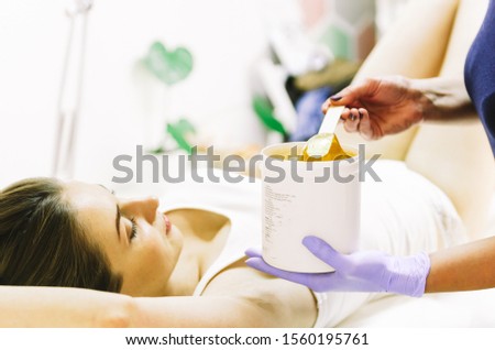 woman doing hot sugar wax hair removal 