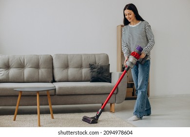 Mujer haciendo trabajo doméstico con aspiradora recargable