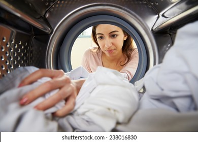 Woman Doing Laundry Reaching Inside Washing Machine