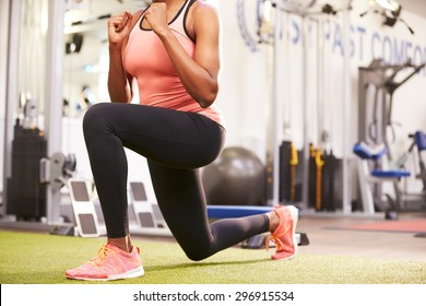 Woman doing lunges in a gym, crop
