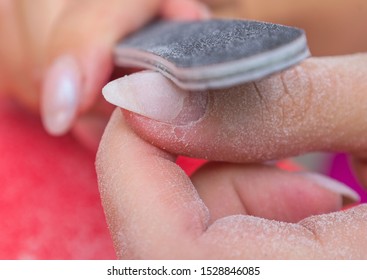 Woman Doing Manicure At Home And Using A Nail File Removes Old Gel Polish From Her Nails. Selective Focus, Close-up. 