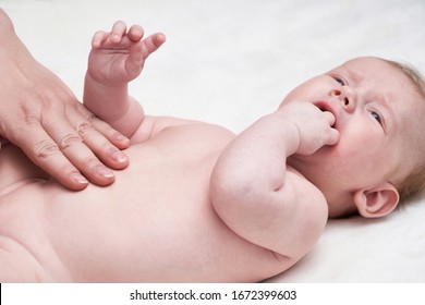 Woman Doing Massage Against Colic Tummy Crying Baby