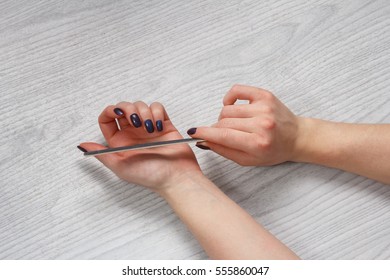 woman doing nails form nail file - Shutterstock ID 555860047