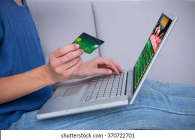 Woman Doing Online Shopping With Laptop And Credit Card Against Gambling App Screen