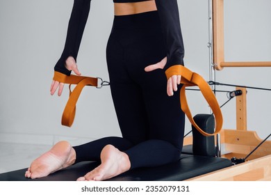 Woman doing Pilates exercise on pilates machine. Back view - Powered by Shutterstock