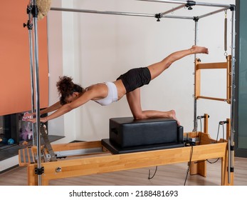 Woman doing pilates moves with reformer in studio - Powered by Shutterstock