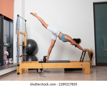 Woman doing pilates moves with reformer in studio - Powered by Shutterstock