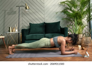 Woman doing plank exercise in the living room - Powered by Shutterstock