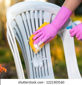 Woman Doing Plastic Chair Cleaning With Spray Foam, Close-up 