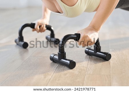 Woman doing push-ups using a push-up bar