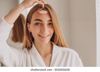 Woman Doing Self Massage With Rose Quartz Face Roller