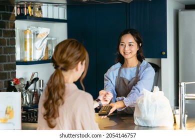 Woman doing smartwatch settlement at cafe (restaurant)