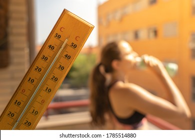 Woman doing sport with hot weather and termometer temperature with hot temperature