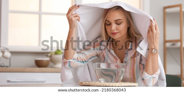 Woman doing steam inhalation at home to soothe\
and open nasal passages