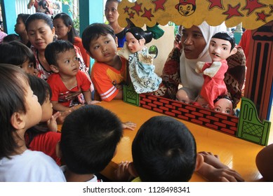 a woman was doing a story-telling activity using hand puppets to entertain the children in eastern Surabaya city of eas java indonesia on 20 March 2014. - Shutterstock ID 1128498341