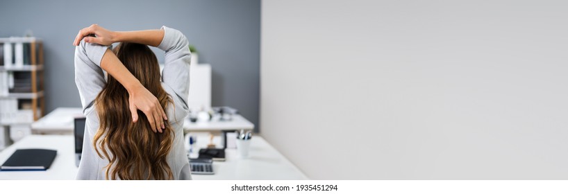 Woman Doing Stretching Exercise In Office At Desk - Shutterstock ID 1935451294