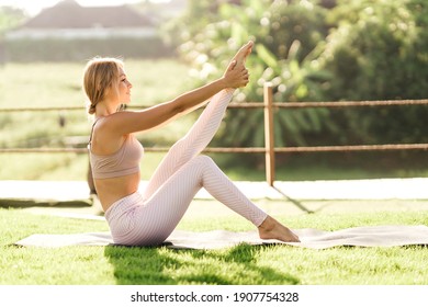 Woman Doing Stretching Exercises Outdoors In The Morning. Beautiful Happy Sport Fitness Model Outside On Summer Spring Day.